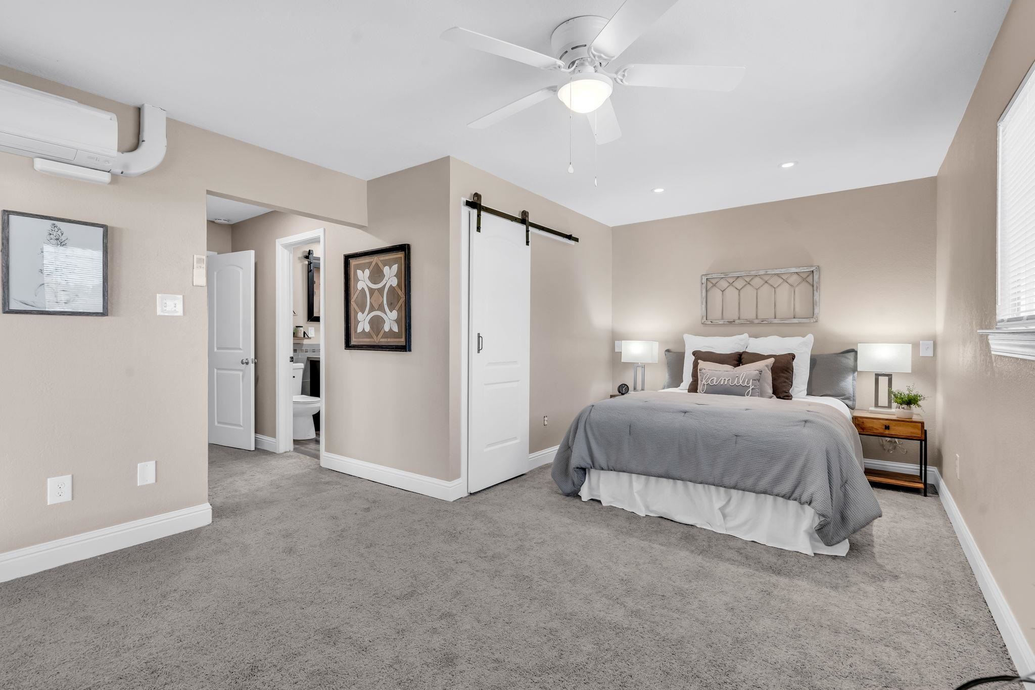 1660 Sunset Road Brentwood, CA 94513 - Photo 28 of 45 Bedroom featuring a barn door, light carpet, a ceiling fan, connected bathroom, and recessed lighting