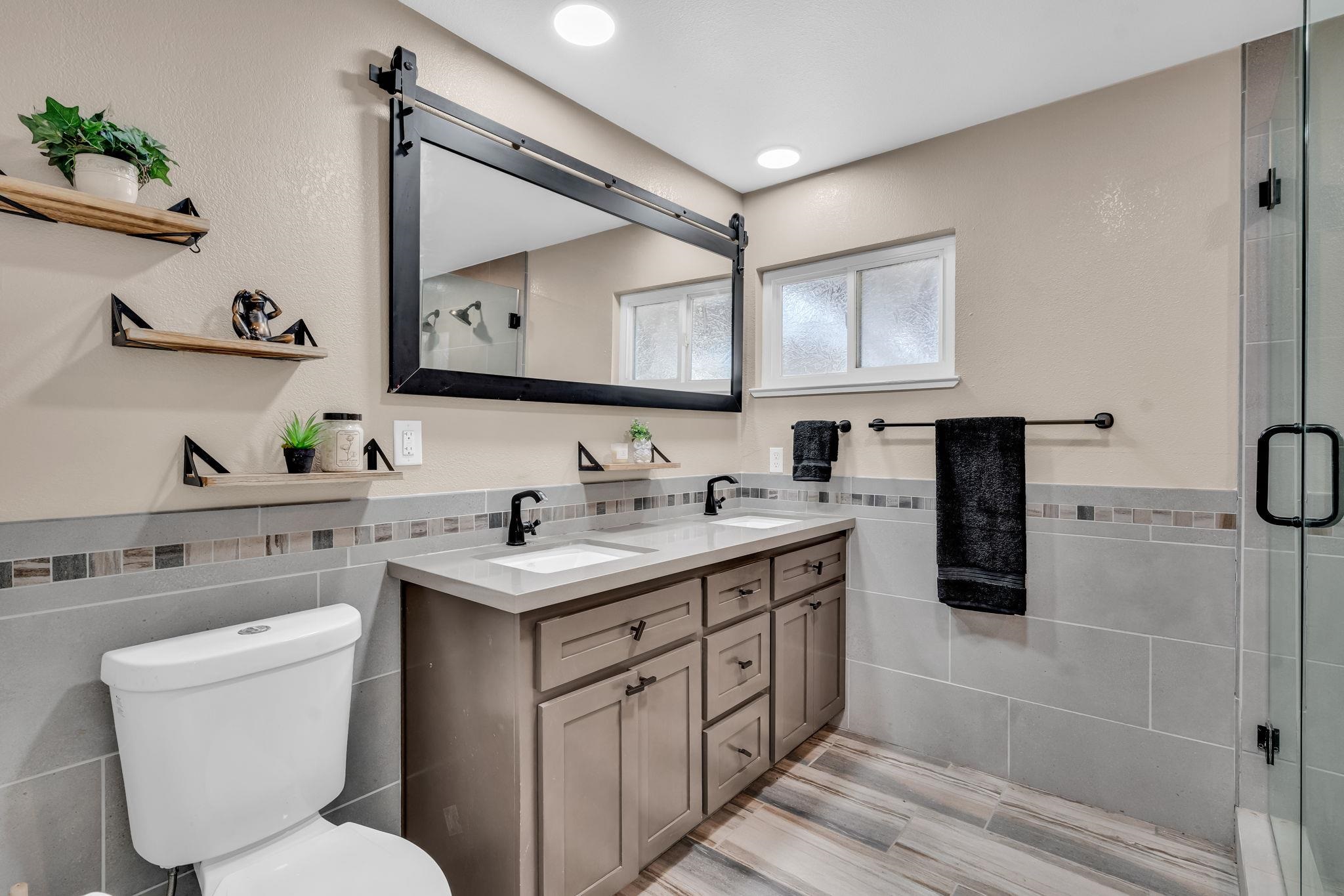 1660 Sunset Road Brentwood, CA 94513 - Photo 30 of 45 Full bath with tile walls, double vanity, a wainscoted wall, and a shower stall