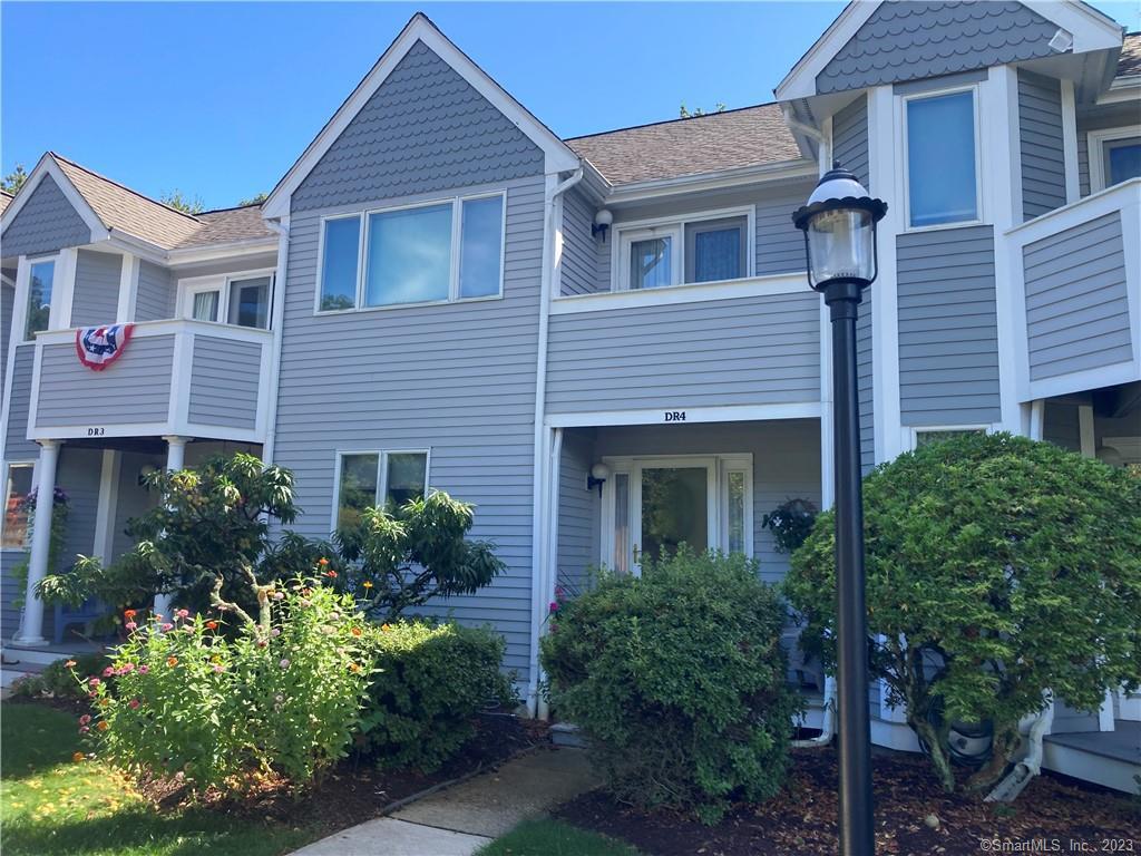 59 Old Post Road, Unit DR4 Clinton, CT 06413 - Photo 1 of 1 a front view of a house with plants and garden