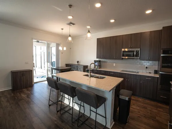a kitchen with stainless steel appliances granite countertop a sink a stove and a wooden floors