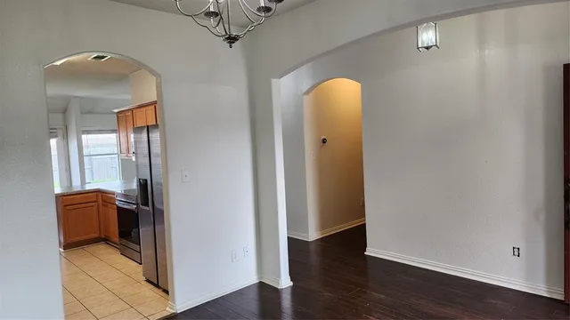 an empty room with wooden floor and mirror
