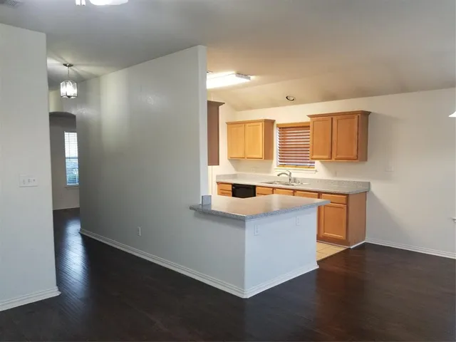 a kitchen with stainless steel appliances granite countertop a sink a stove and a wooden floors