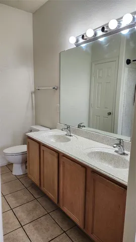 a bathroom with a granite countertop sink a toilet and a mirror