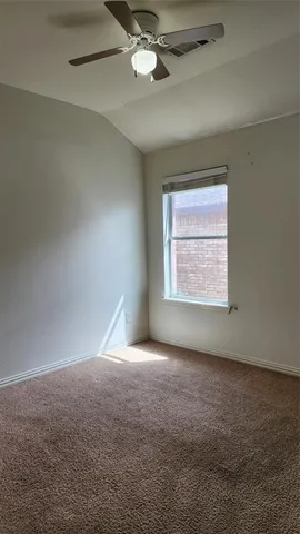 en empty room with windows and ceiling fan