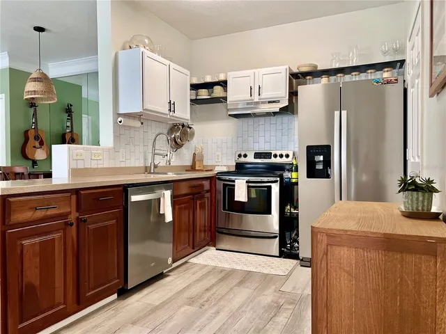 a kitchen with stainless steel appliances a sink and a refrigerator