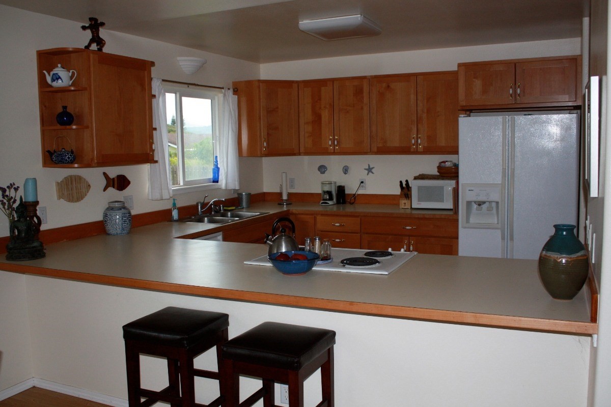 341 Eggerking Road, Unit 1 Kapaa, HI 96746 - Photo 3 of 10 a kitchen with a sink a stove and a refrigerator