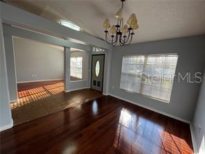 4 Pin Oak Drive Palm Coast, FL 32164 - Photo 3 of 15 a view of an empty room with wooden floor and a window