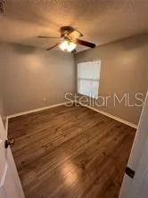 a view of an empty room with a chandelier fan