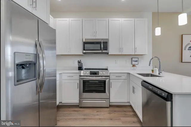 a kitchen with stainless steel appliances granite countertop a refrigerator sink and stove