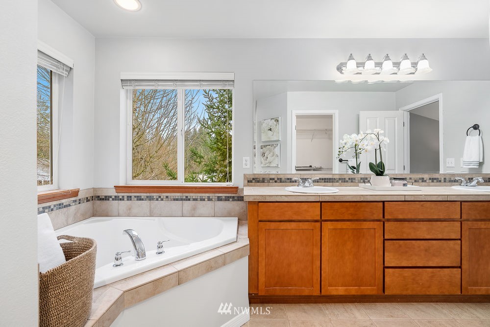 17813 20th Avenue Southeast, Unit 57 Bothell, WA 98012 - Photo 18 of 25 a bathroom with a tub a sink and a large mirror