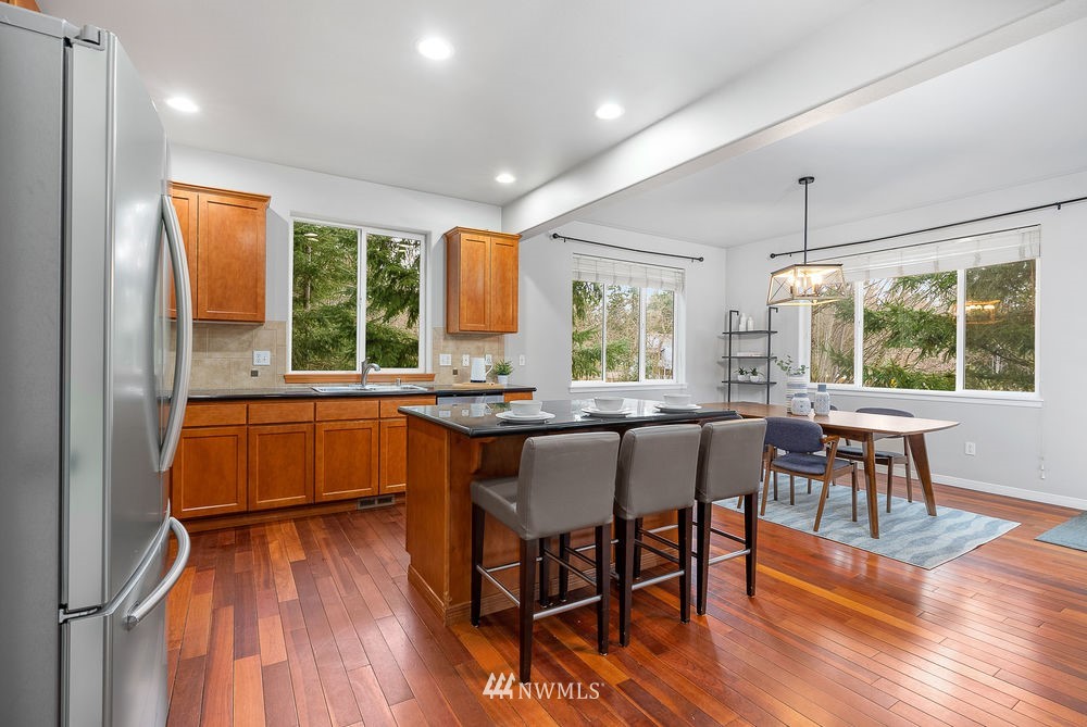 17813 20th Avenue Southeast, Unit 57 Bothell, WA 98012 - Photo 6 of 25 a kitchen with a table chairs sink and cabinets