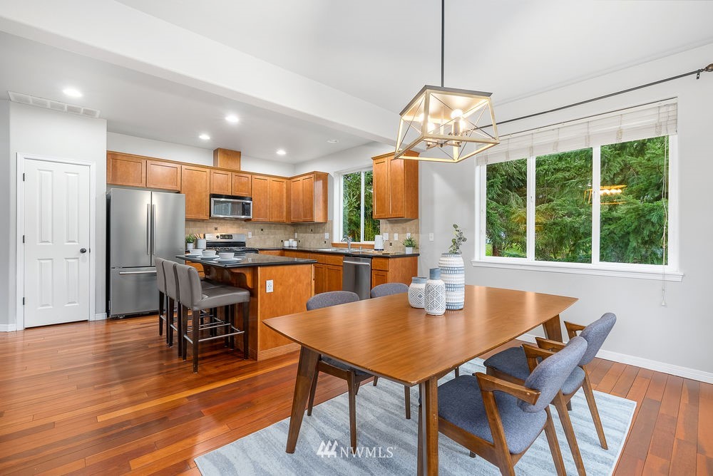 17813 20th Avenue Southeast, Unit 57 Bothell, WA 98012 - Photo 7 of 25 a dining room with furniture a chandelier and wooden floor