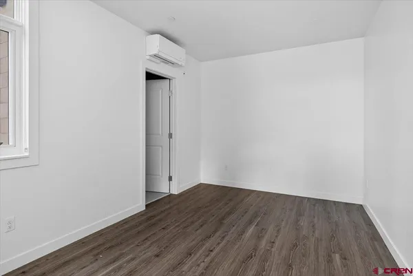 a view of a small space with wooden floor and a window