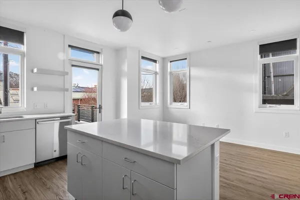 a kitchen with granite countertop a sink and dishwasher with wooden floor
