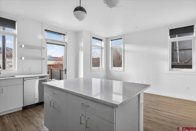 a kitchen with granite countertop a sink and dishwasher with wooden floor