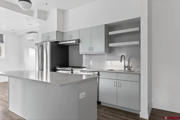 a kitchen with stainless steel appliances a sink and a refrigerator