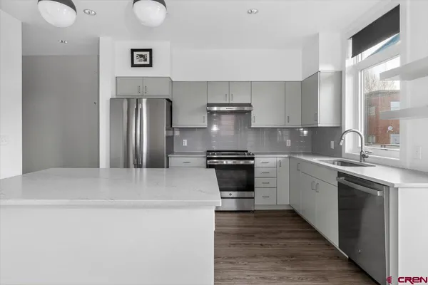 a kitchen with stainless steel appliances granite countertop a sink stove and refrigerator