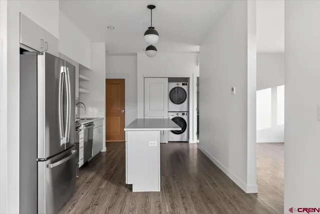a view of a kitchen with a refrigerator and wooden floor