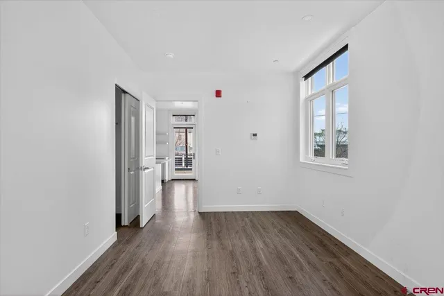 a view of a kitchen with wooden floor and a window