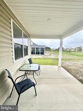 a view of a porch with furniture and a yard