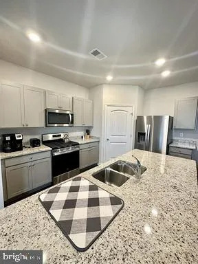 a kitchen with a stove a refrigerator and a sink