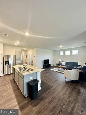 a large kitchen with a stove and wooden floor