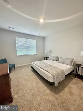 a bedroom with a bed and a dresser next to a window