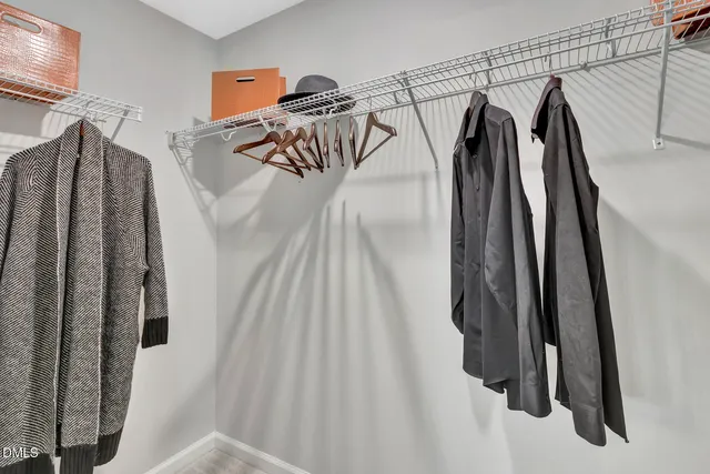 a view of walk in closet with clothes