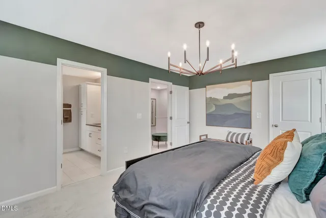 a bedroom with a bed chandelier and a window