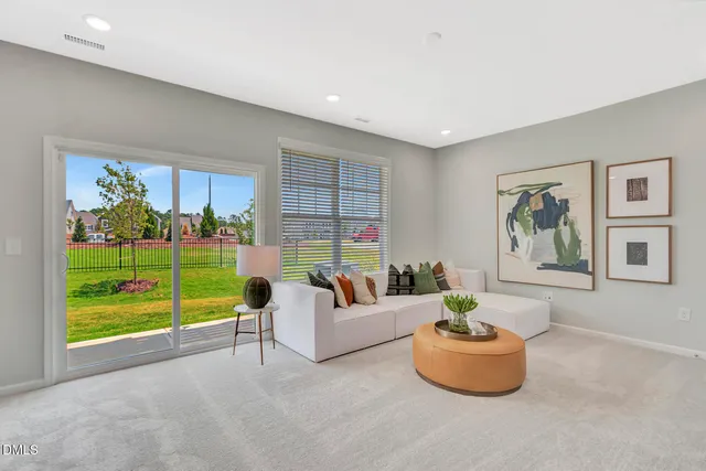 a living room with furniture and a floor to ceiling window