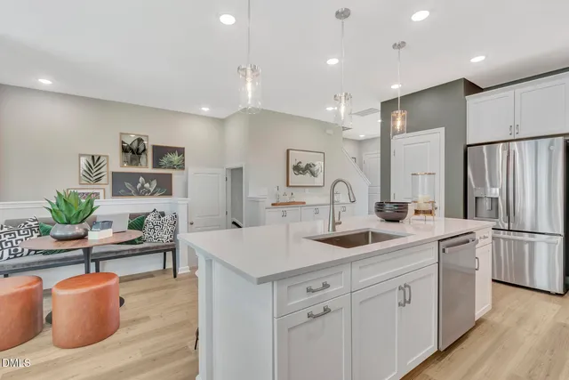 a kitchen with stainless steel appliances granite countertop a sink and a refrigerator
