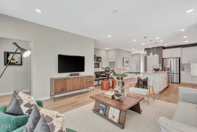 a living room with furniture kitchen view and a flat screen tv