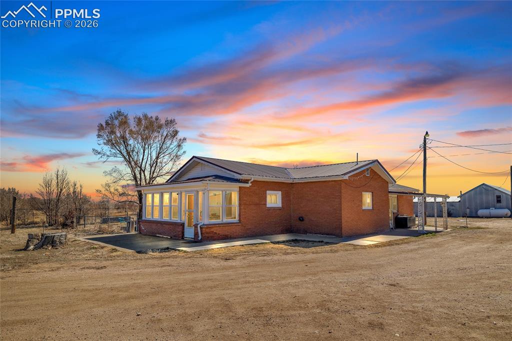 68300 Highway 50 Fowler, CO 81039 - Photo 1 of 49 Back of property featuring brick siding, a metal roof, and a patio