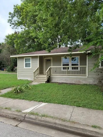 a front view of a house with a garden and yard