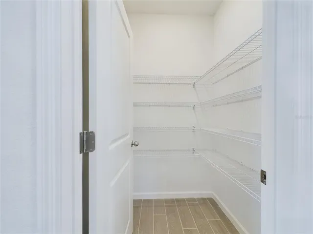 a view of walk in closet with empty racks