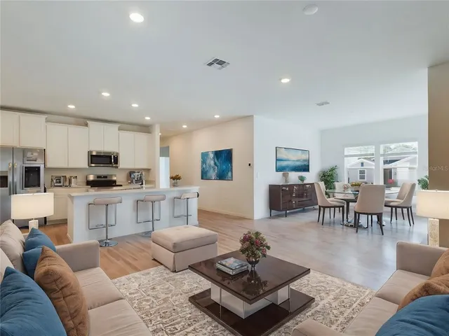 a living room with furniture kitchen view and a table