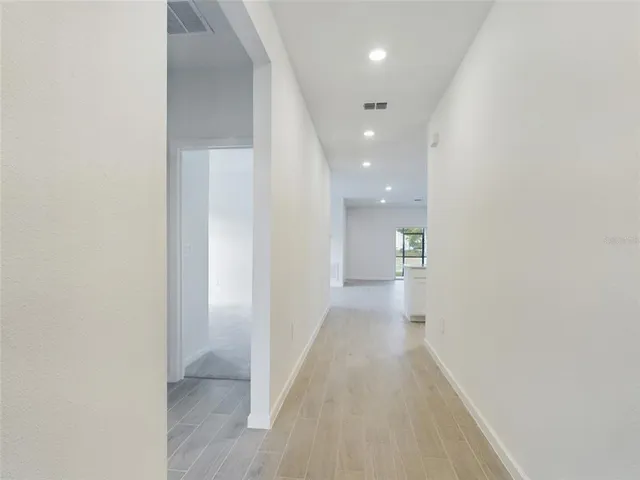 a view of a hallway with wooden floor