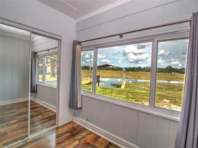 a view of a room with wooden floor and windows