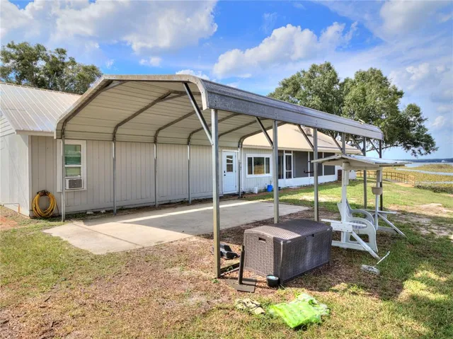 a view of a chair and table in backyard of the house