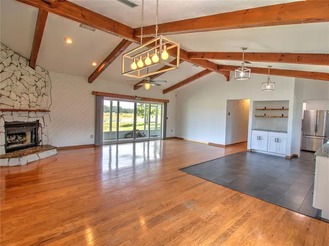 a view of a room with wooden floor and a ceiling fan