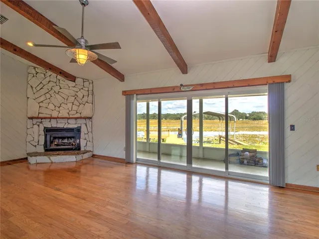a view of an empty room with a fireplace and a window