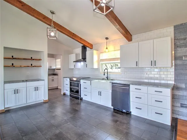 a kitchen with granite countertop white cabinets and white appliances