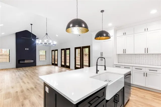 a kitchen with cabinets a center island and stainless steel appliances