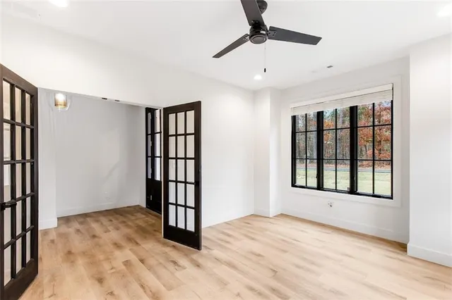 a view of an empty room with a window and wooden floor