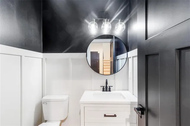 a bathroom with a toilet sink and mirror