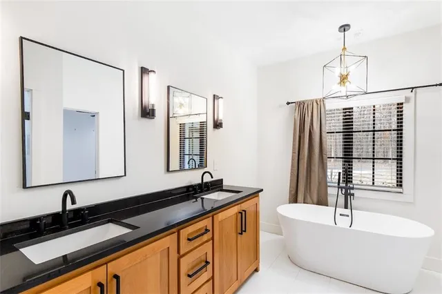 a bathroom with a granite countertop sink and a bathtub