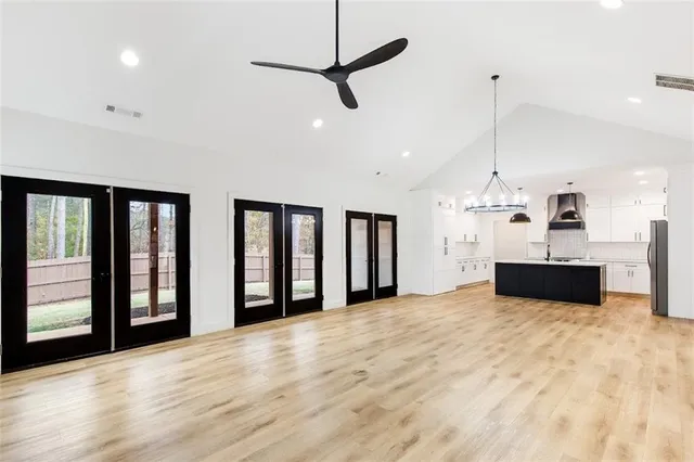 a view of an empty room with a kitchen and a window