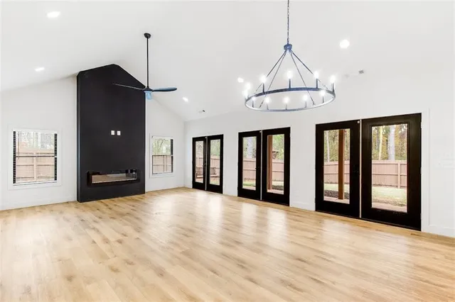 a view of an empty room with a window and kitchen view