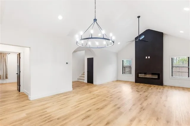 a view of a room with wooden floor a ceiling fan and kitchen space