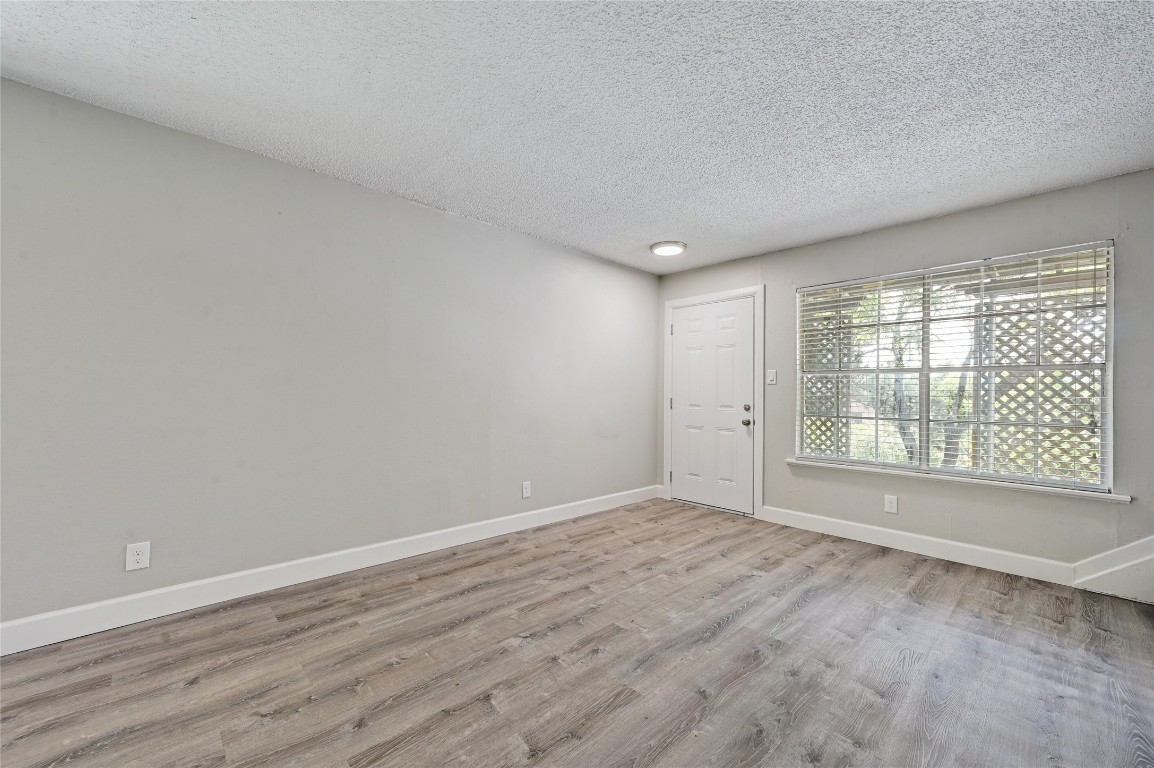 1200 Banister Lane, Unit 5 Austin, TX 78704 - Photo 4 of 13 a view of an empty room with wooden floor and a window